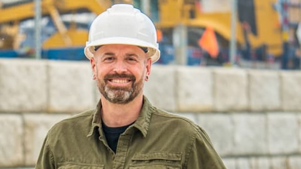 entrepreneur debout sur chantier extérieur avec casque blanc